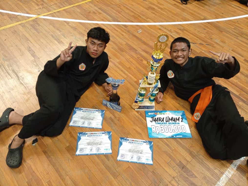 Santri SMA Ar-Rohmah Putra Malang, Manggala Ananta Janitra Nayotama, menerima penghargaan sebagai Pesilat Remaja Putra Terbaik dalam ajang Batu Championship 2 tingkat Provinsi Jawa Timur yang diselenggarakan oleh IPSI Kota Batu. Dalam kejuaraan ini, tim pencak silat SMA Ar-Rohmah Putra juga berhasil meraih Juara Umum II. Foto menampilkan momen kebanggaan para pesilat muda Ar-Rohmah berpose di podium dengan medali dan piagam penghargaan.